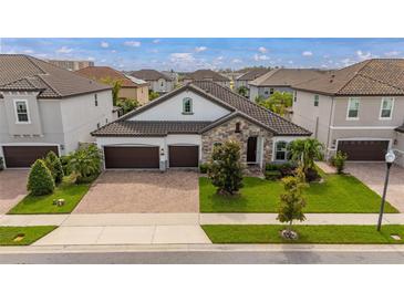 Two-story home with stone accents and a two-car garage at 8361 Ludington Cir, Orlando, FL 32836