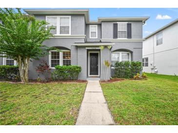 Two-story house with gray siding, black door, and landscaped lawn at 14236 Golden Rain Tree Blvd, Orlando, FL 32828
