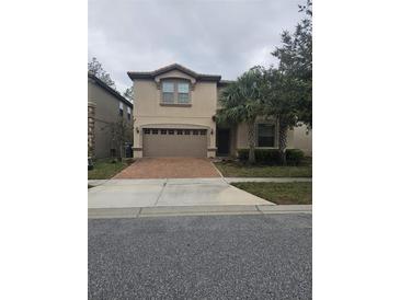 Two-story house with a brown brick driveway and palm trees at 1662 Lima Ave, Kissimmee, FL 34747