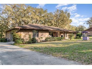 Charming single-story brick home with a well-manicured lawn and mature trees at 2351 Mandarin Rd, Deland, FL 32720