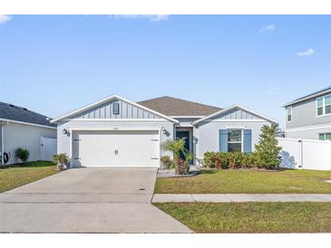 Two-story home with gray siding, white garage door, and landscaped lawn at 3158 Sweet Acres Pl, St Cloud, FL 34772