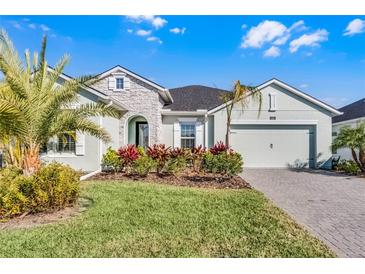 One-story home with light green exterior, landscaping, and paver driveway at 636 Mosaic Blvd, Daytona Beach, FL 32124