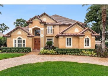 Two-story house with tile roof, landscaping, and brick driveway at 10018 Lone Tree Ln, Orlando, FL 32836
