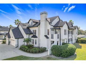 Two-story home with a white exterior, dark roof, and landscaping at 13407 Fountainbleau Dr # 5-2, Clermont, FL 34711
