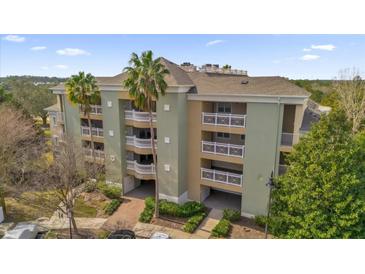 Exterior of a three-story building with balconies and palm trees at 1358 Centre Court Ridge Dr # 202, Reunion, FL 34747