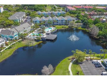 Aerial view of community with lake, pool, and colorful buildings at 3013 Bonfire Beach Dr # 101, Kissimmee, FL 34746