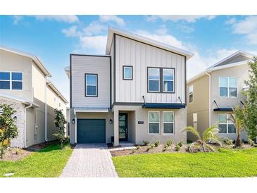 Two-story modern home with gray siding and a gray garage door at 4152 Paragraph Dr, Kissimmee, FL 34746