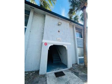 Exterior view of a light-colored building with stairs leading to the entrance at 4771 S Texas Ave # 4771C, Orlando, FL 32839