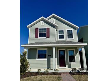 Two-story house with green siding, burgundy door, and landscaping at 520 Orient Ave, Debary, FL 32713