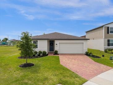 Single-story home with brick paver driveway and landscaped lawn at 1231 Citrus Landings Blvd, Davenport, FL 33837