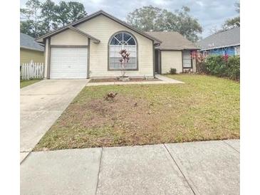Ranch style home with attached garage and a well-maintained lawn at 12703 Whiterapids Dr, Orlando, FL 32828