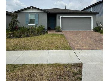 Charming single-story home with brick driveway, well-maintained landscaping, and a two-car garage at 3072 Cassidy Ln, Haines City, FL 33844