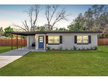 Newly renovated home with carport, modern facade, and manicured lawn at 4722 Halliday Ln, Orlando, FL 32810