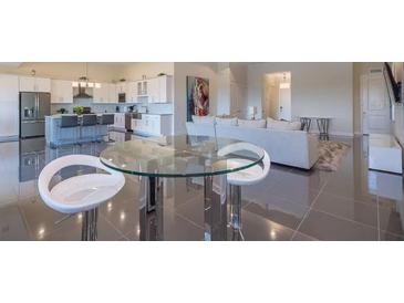 Bright, open-concept living space with modern furnishings and a sleek dining area at 4731 Clock Tower Dr # 401, Kissimmee, FL 34746