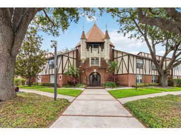 Unique condo building featuring brick and Tudor-style architecture with turrets and lush landscaping at 5413 Hansel Ave # K10, Orlando, FL 32809