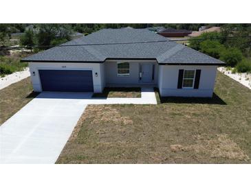 Inviting single-story home featuring a pristine driveway and attached garage at 6618 Sw 128Th Pl, Ocala, FL 34473