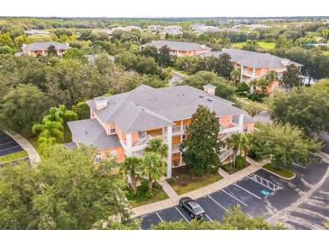 Aerial view of a two-story condo building with ample parking at 114 Watling Way # 114, Davenport, FL 33897