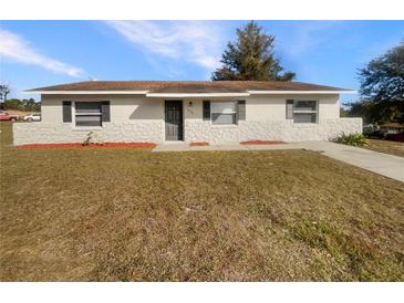 Cute one-story home with stone facade and well-maintained lawn at 1490 Lake Opal Dr, Apopka, FL 32703