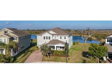 Two-story house with lake view, landscaped yard, and paved driveway at 15107 Lake Claire Overlook Dr, Winter Garden, FL 34787