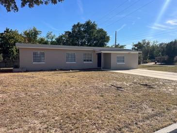 Charming single-story home features a well-maintained exterior and a spacious front yard with beautiful mature trees at 1601 Pontiac Ct, Orlando, FL 32808