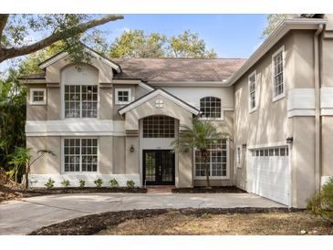 Two-story house with a neutral color palette and a three-car garage at 1700 Bridlewalk Ct, Gotha, FL 34734