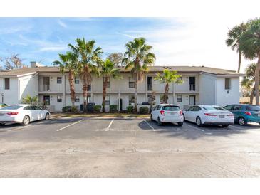 Front view of condo building with parking and palm trees at 2960 Plaza Terrace Dr # 2960, Orlando, FL 32803