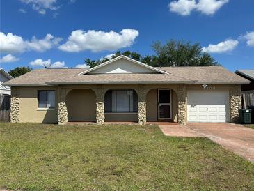 Charming single-story home featuring a stone-accented front porch and attached one-car garage at 3303 Jon Jon Dr, Orlando, FL 32822