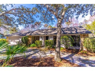Ranch-style home with mature landscaping and a large oak tree in the front yard at 400 Magnolia Oak Dr, Longwood, FL 32779