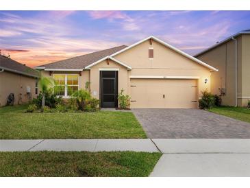 Charming single-story home featuring a well-manicured lawn, a two-car garage, and lovely landscaping at 523 Lazio Cir, Debary, FL 32713