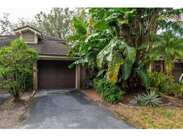 Private garage with lush landscaping and driveway at 7616 Spring Bay Cv # S, Orlando, FL 32819