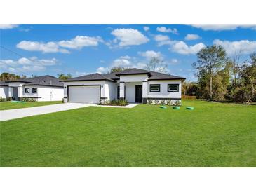 Newly constructed home with a spacious lawn and attached garage at 13497 Se 100Th Ave, Belleview, FL 34420