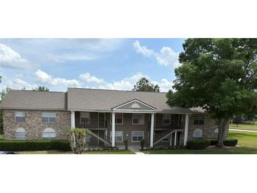 Multi-Gathering unit with brick accents, exterior stairs, and mature landscaping at 144 Reserve Cir # 112, Oviedo, FL 32765