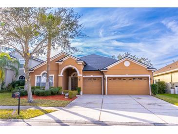 Two-story house with a three-car garage and landscaped yard at 2048 Gloria Oak Ct, Orlando, FL 32820