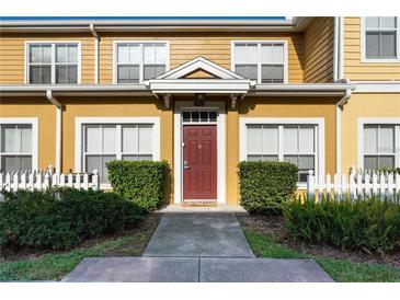 Charming yellow two-story townhome with well-manicured landscaping and inviting front entrance at 2622 Lodi Cir # 103, Kissimmee, FL 34746
