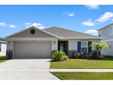 One-story home with a two-car garage, landscaping, and a neutral color palette at 3220 Sweet Acres Pl, St Cloud, FL 34772
