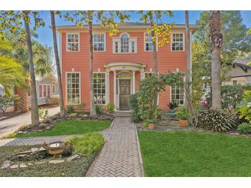 Charming two-story coral home with landscaped front yard and brick pathway at 817 Antonette Ave, Winter Park, FL 32789
