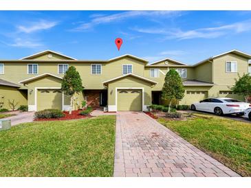 Two-story townhome with two-car garage and landscaped front yard at 1927 Chatham Place Dr, Orlando, FL 32824