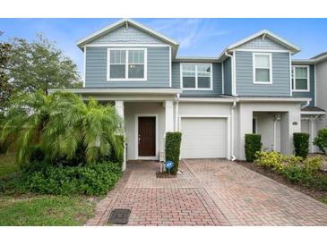 Two-story townhome with gray siding, brick driveway, and landscaping at 4052 Falling Lilly Ct, Winter Springs, FL 32708