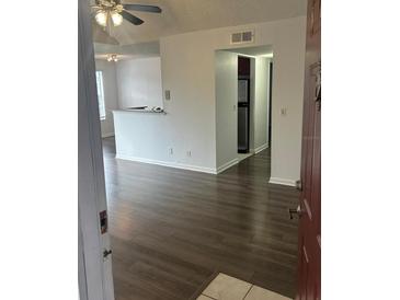 Bright living room with wood-look floors and access to kitchen at 11568 Westwood Blvd # 1034, Orlando, FL 32821