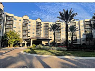 Luxury condominium exterior with covered entrance, lush landscaping, and multiple floors with private balconies at 14501 Grove Resort Ave # 1407, Winter Garden, FL 34787