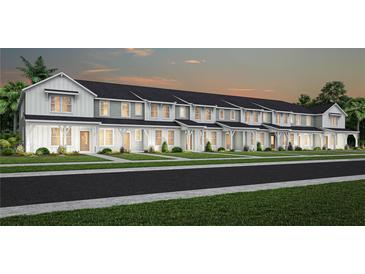 Row of townhouses with farmhouse-style architecture and landscaping at 2347 Southbury Dr, Kissimmee, FL 34744
