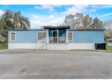 Charming blue home featuring a cozy front porch and ample parking space at 2432 4Th St, Orlando, FL 32820