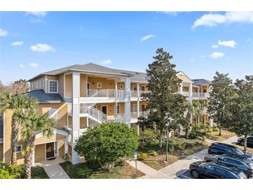 Two-story condo building with inviting landscaping and ample parking at 114 Rum Run, Davenport, FL 33837