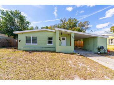 Charming light green house with a carport and well-maintained lawn at 1232 Saint James Rd, Orlando, FL 32808