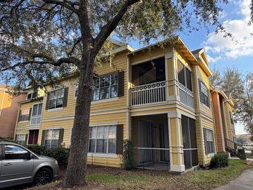 Charming yellow two-story home with a screened-in porch and balcony offering a cozy outdoor space at 2328 Midtown Ter # 1024, Orlando, FL 32839