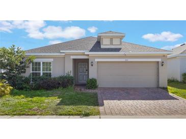 Charming single-story home featuring a brick driveway and well-maintained landscaping at 253 Golden Sands Cir, Davenport, FL 33837