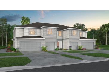Two-story townhome with gray siding, three-car garage, and landscaping at 2582 Winsome Way, Davenport, FL 33896