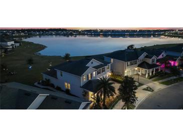 Beautiful aerial view of a home by a lake with manicured lawns and vibrant community during a stunning sunset at 4608 Egg Harbor Dr, Kissimmee, FL 34746