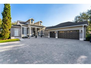 Two-story house with a three-car garage and paver driveway at 6001 Caymus Loop, Windermere, FL 34786