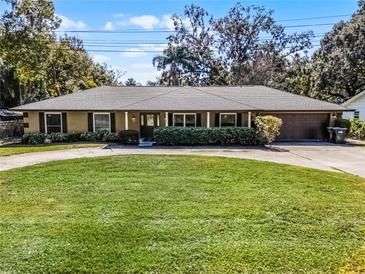 Ranch-style home with a large lawn and attached garage at 718 32Nd St, Orlando, FL 32806